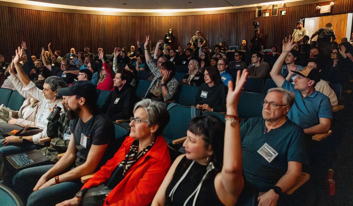 Audience members raising their hands during Andrea Mills's Vancouver AI talk.
