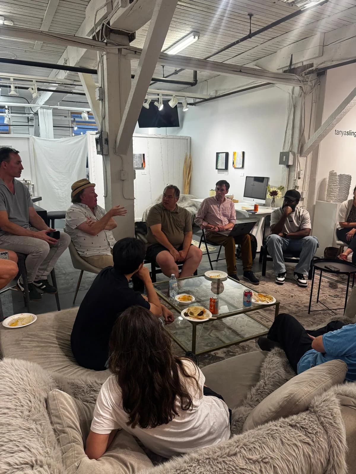 Participants in conversation around a glass table at AI Ethical Futures Lab number 6, one person gesturing while others listen.