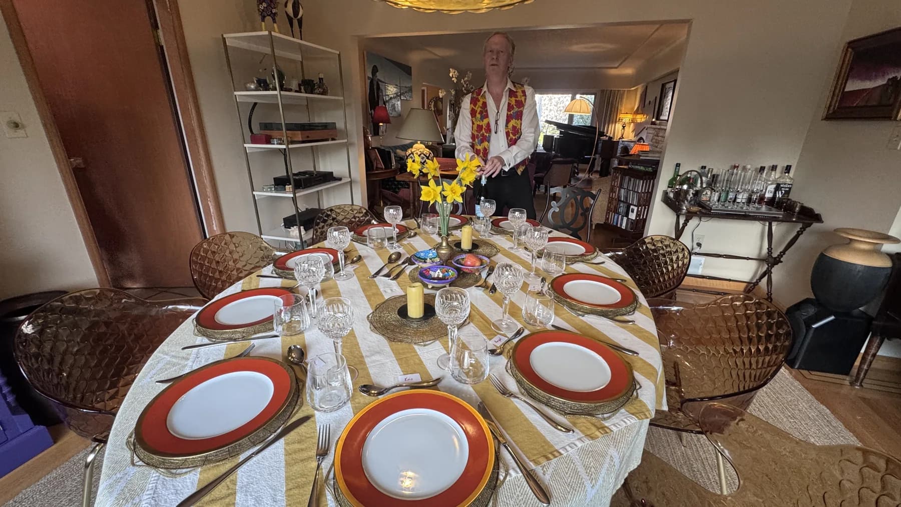 The dining table set for supper with a striped cloth, yellow flowers, and place cards.