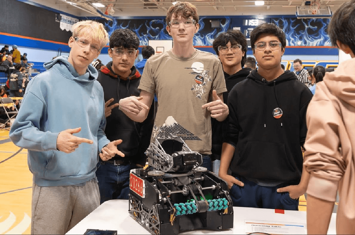 Prince of Wales P.O.W.E.R. students gathered around their FTC competition robot, number 20266.
