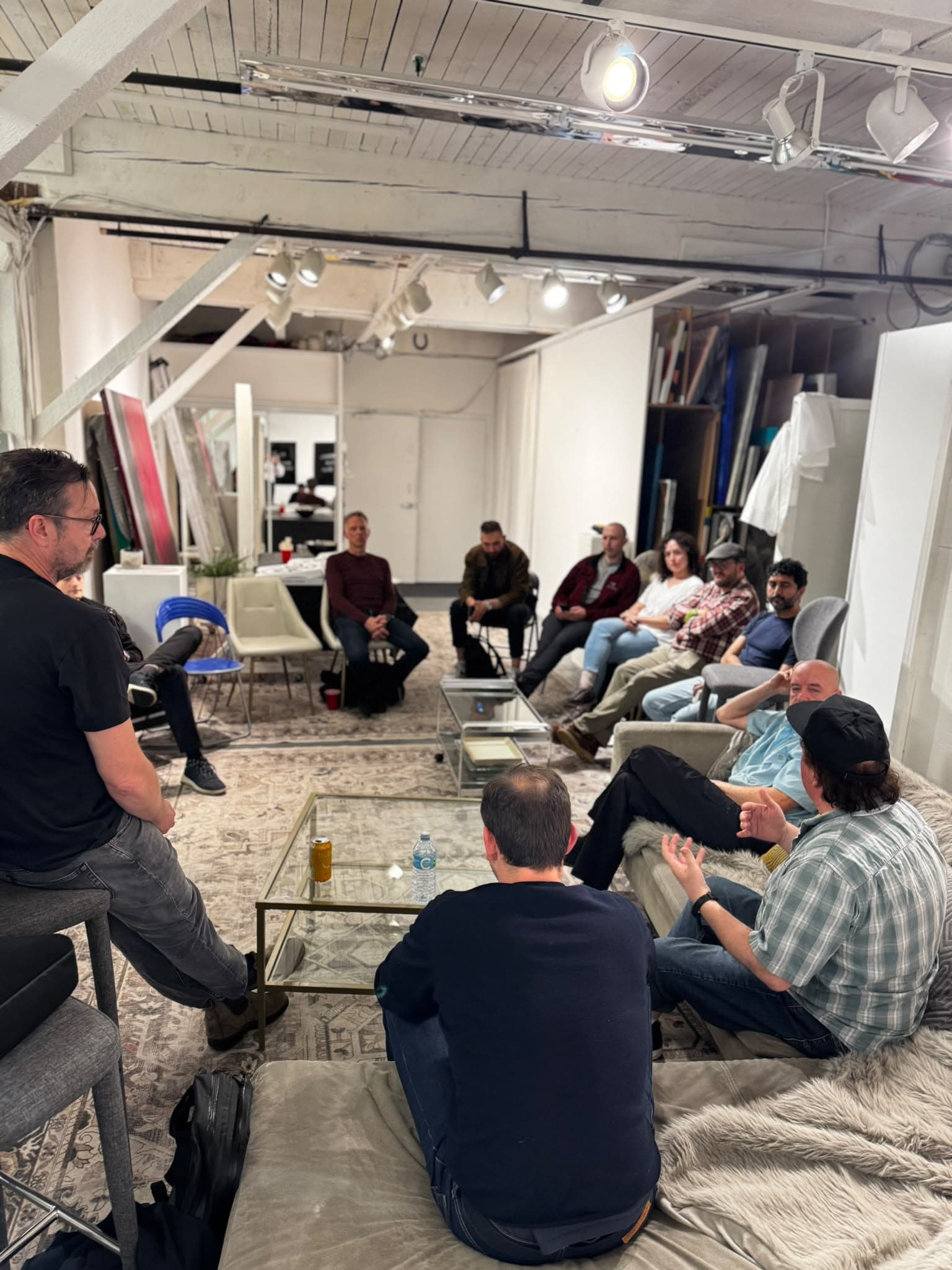 A participant gestures as others listen around the studio.