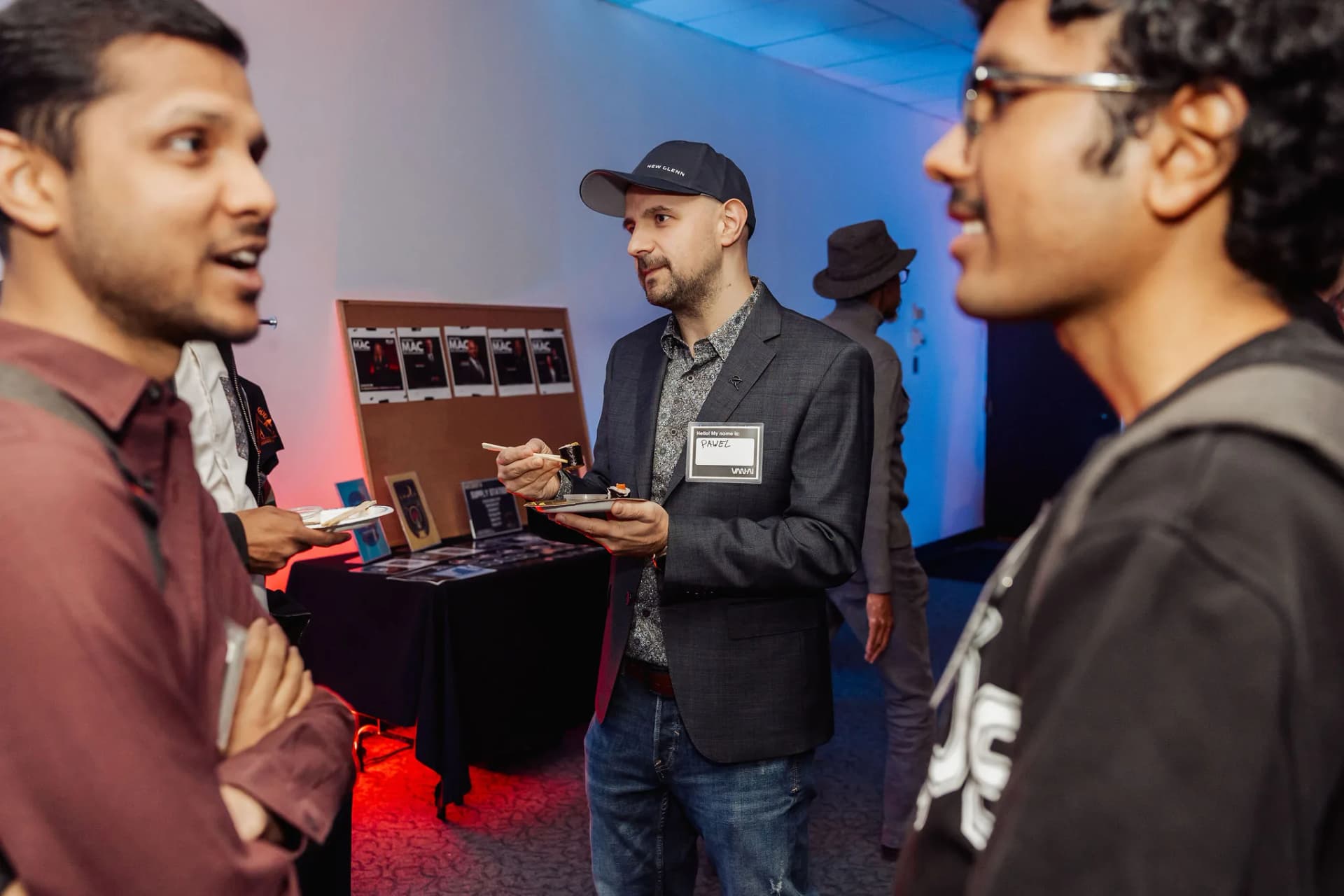 MAC community members beside the Mind, AI and Consciousness table at the February 2026 Takeover.