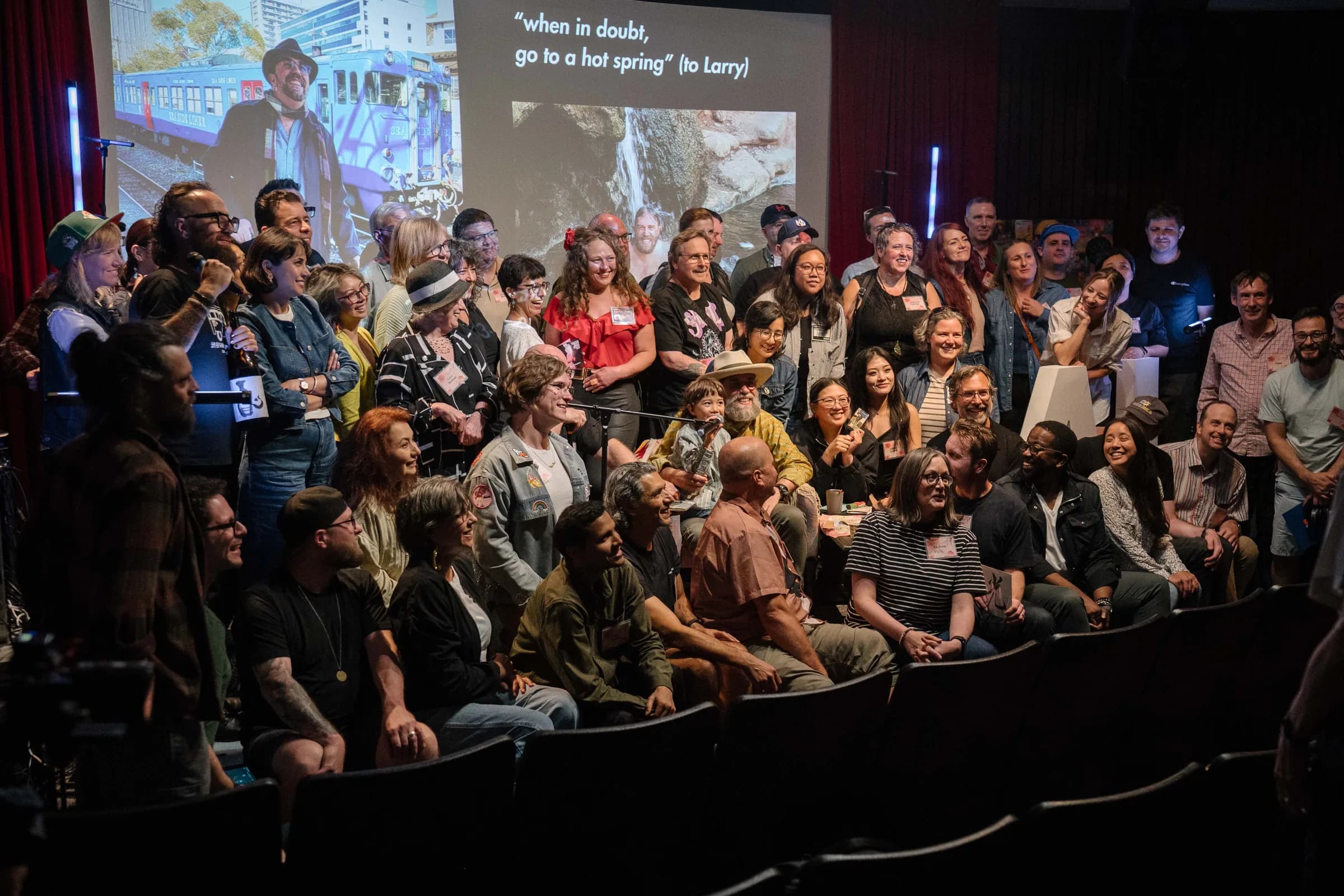 The July meetup gathers on and in front of the stage for a group photo.