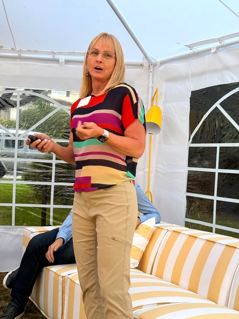 The evening's health-data speaker presenting, clicker in hand, beside the striped seating.
