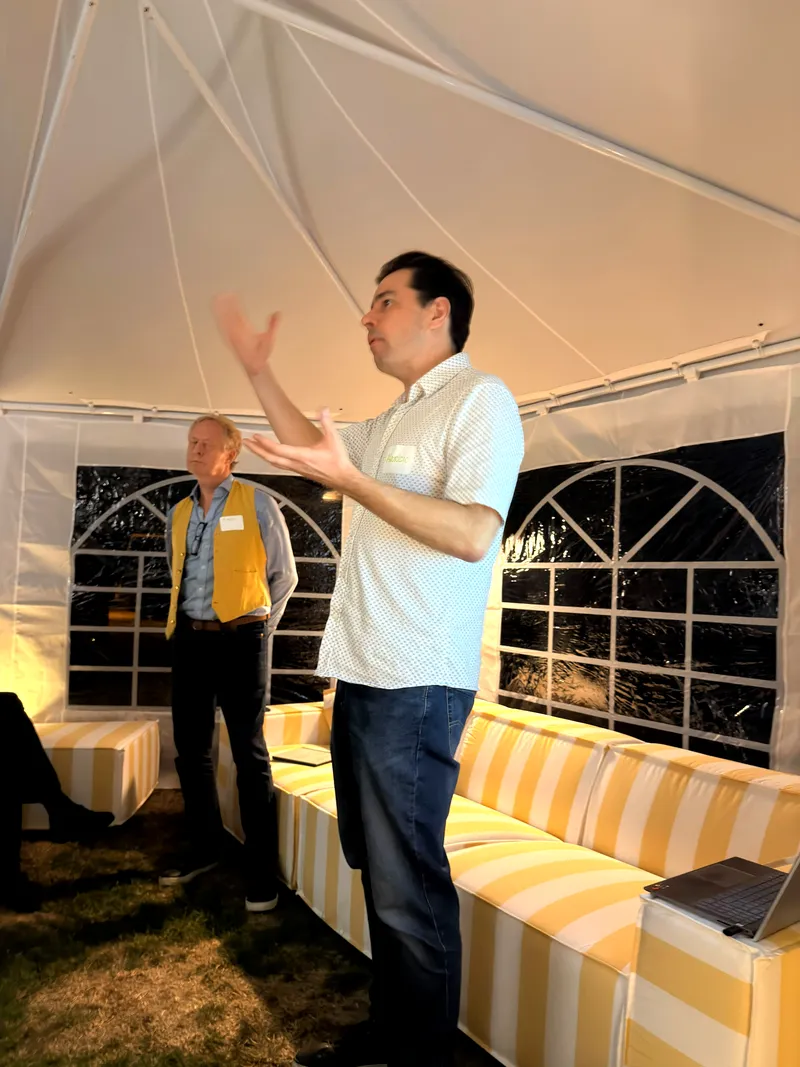A presenter mid-gesture, both hands raised, during the Downtown Eastside programme update.