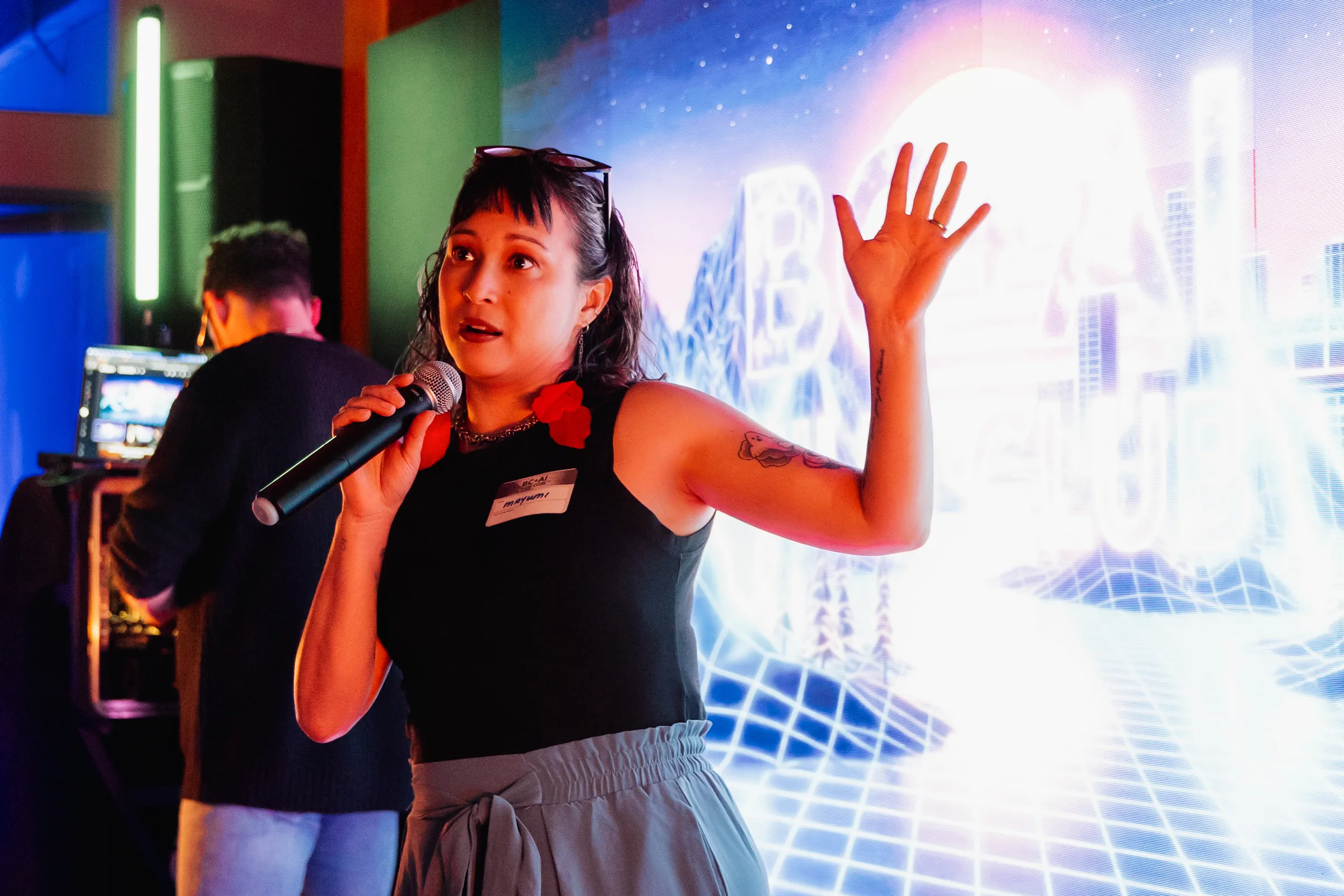 AI Film Club presenter speaking with an animated hand gesture in front of a projection.