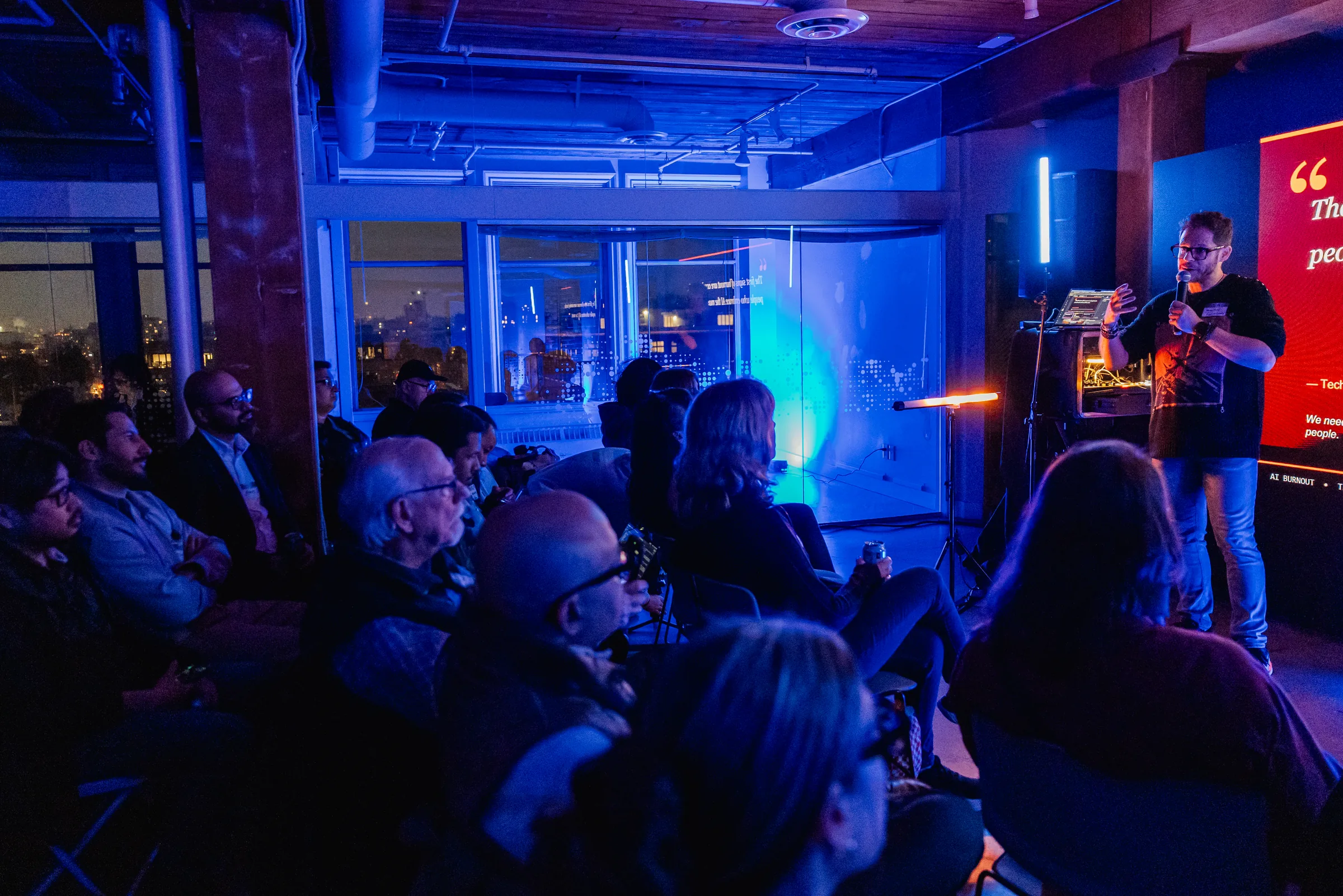 Full room at AI Film Club with audience seated under blue event lighting.
