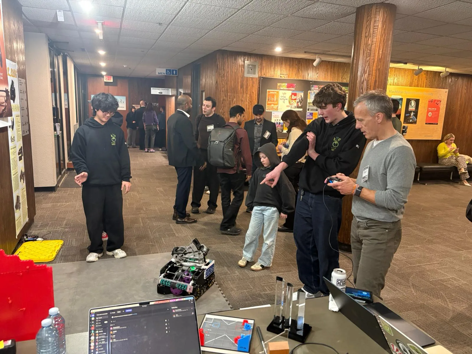 Students demonstrate an FTC robot in the H.R. MacMillan Space Centre lobby during a BC + AI gathering.