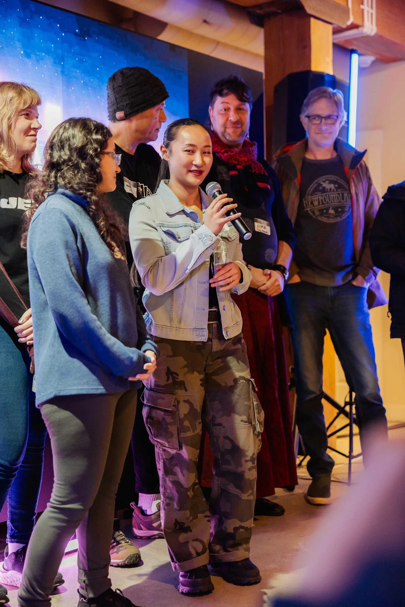 AI Film Club attendee speaking into a microphone with other participants nearby.